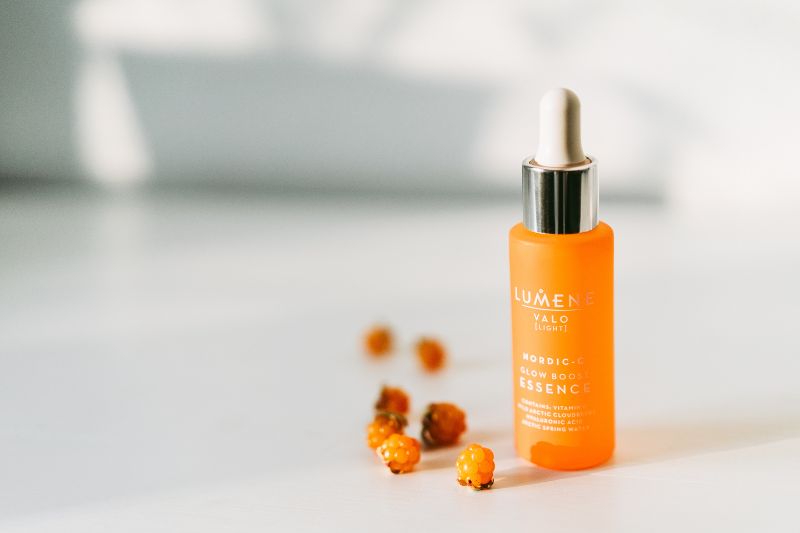 Valkoisella pöydällä Lumene VALO seerumi. Vierellä useita lakkoja.