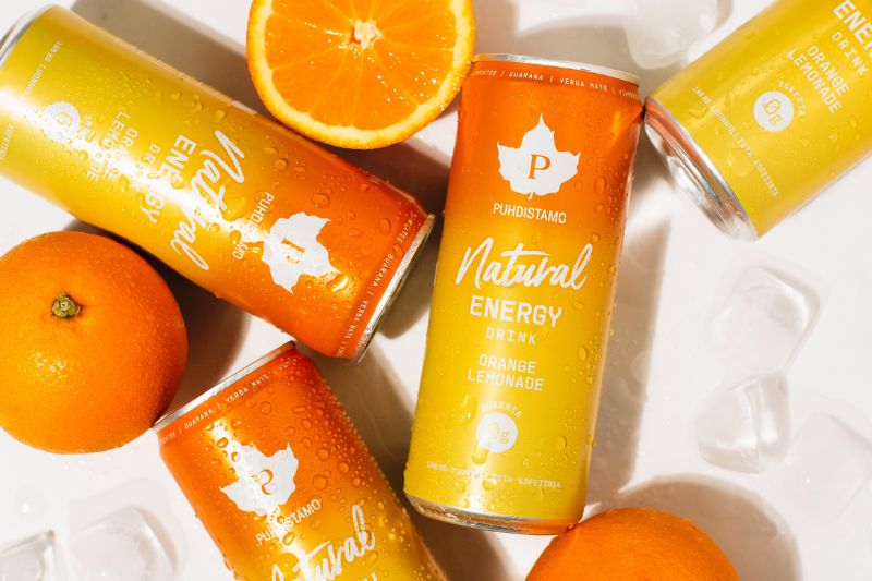 Puhdistamon energiajuomatölkkejä, puolitettuja appelsiineja ja jääpaloja. Päälle roiskittu vettä.